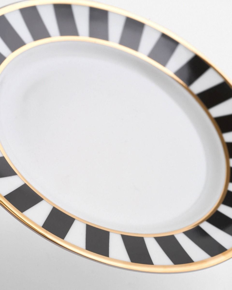 a black and white plate with a gold rim