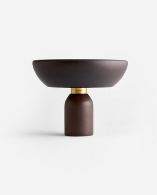 a brown bowl sitting on top of a wooden stand