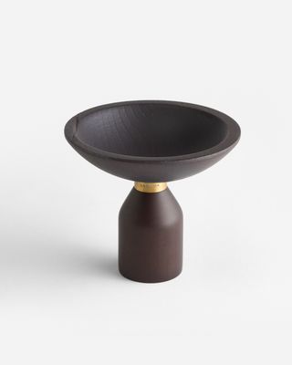 a brown bowl sitting on top of a wooden stand