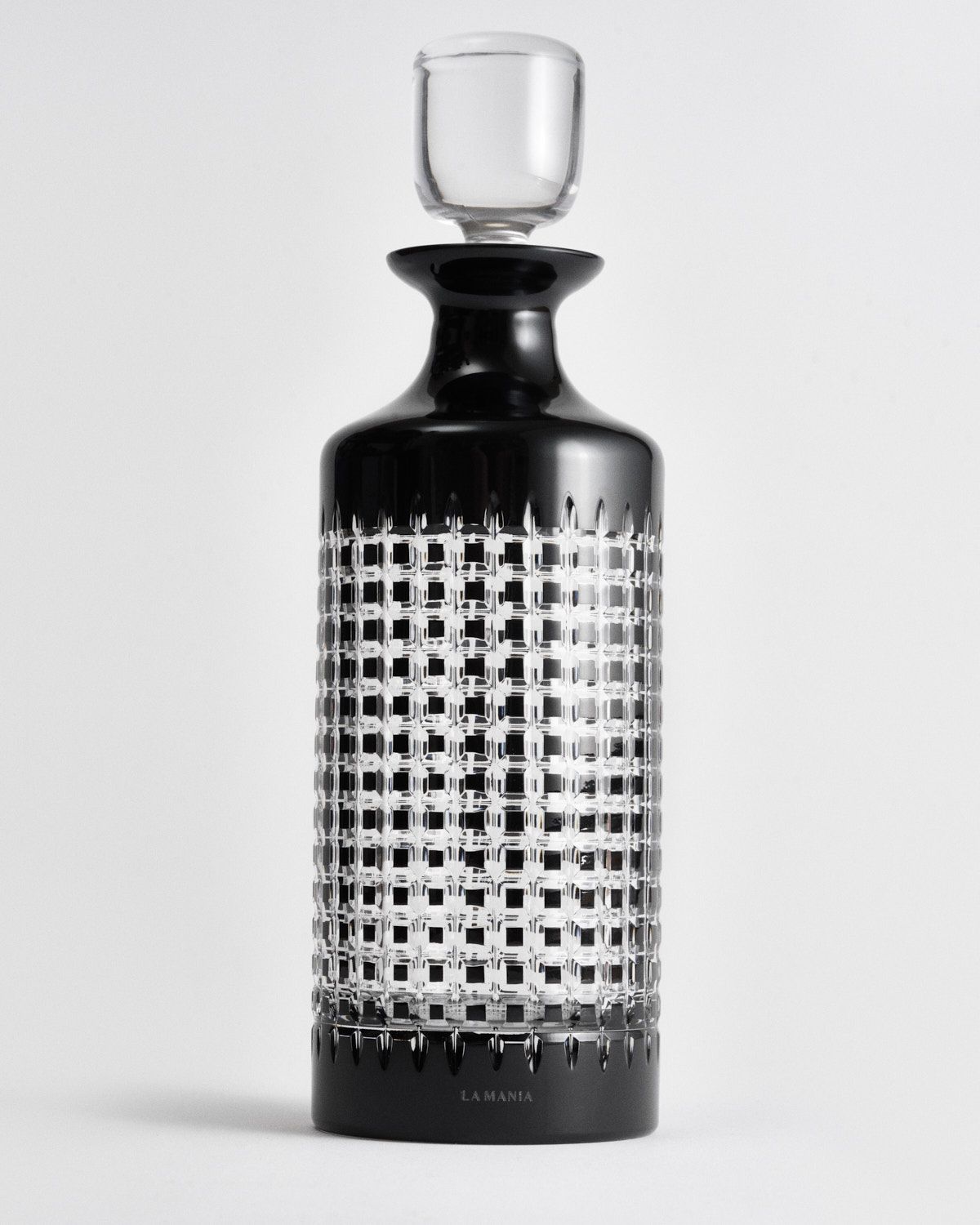 a black and white bottle with a glass on top of it