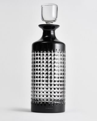 a black and white bottle with a glass on top of it