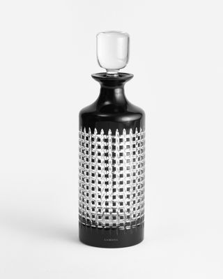a black and white bottle with a glass in it