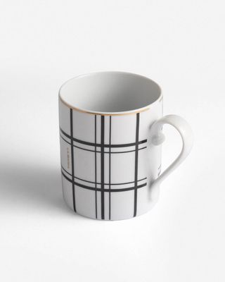 a white coffee cup with a black and white plaid pattern