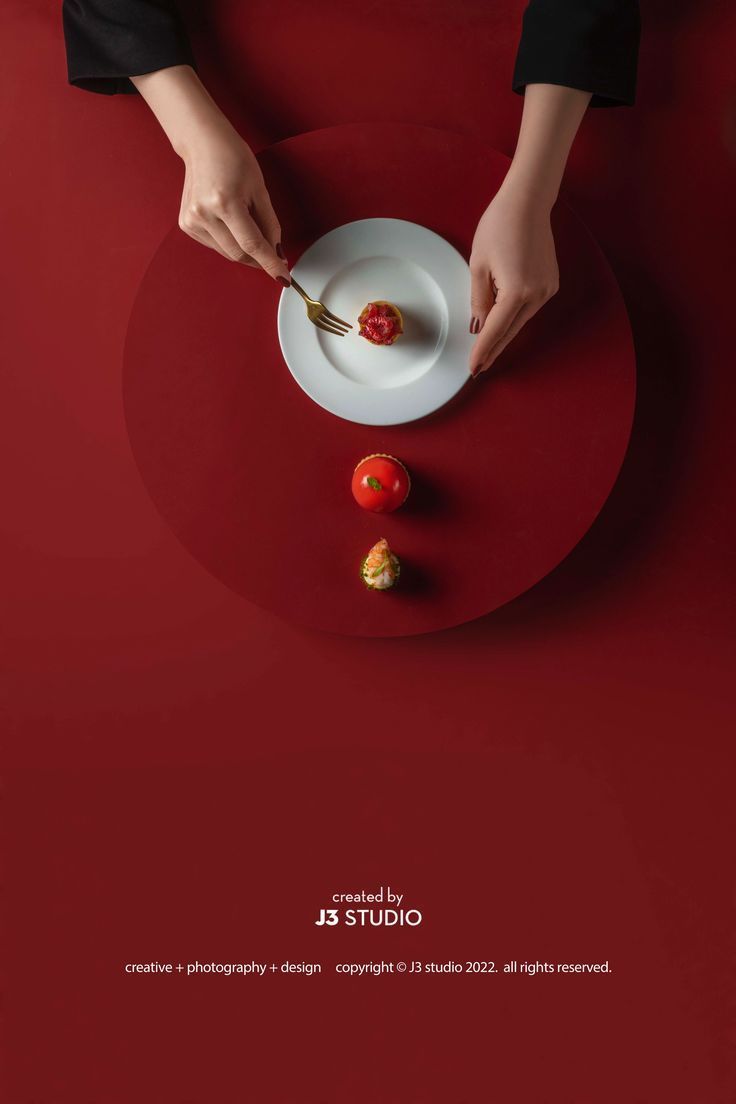 a person is cutting a tomato on a plate