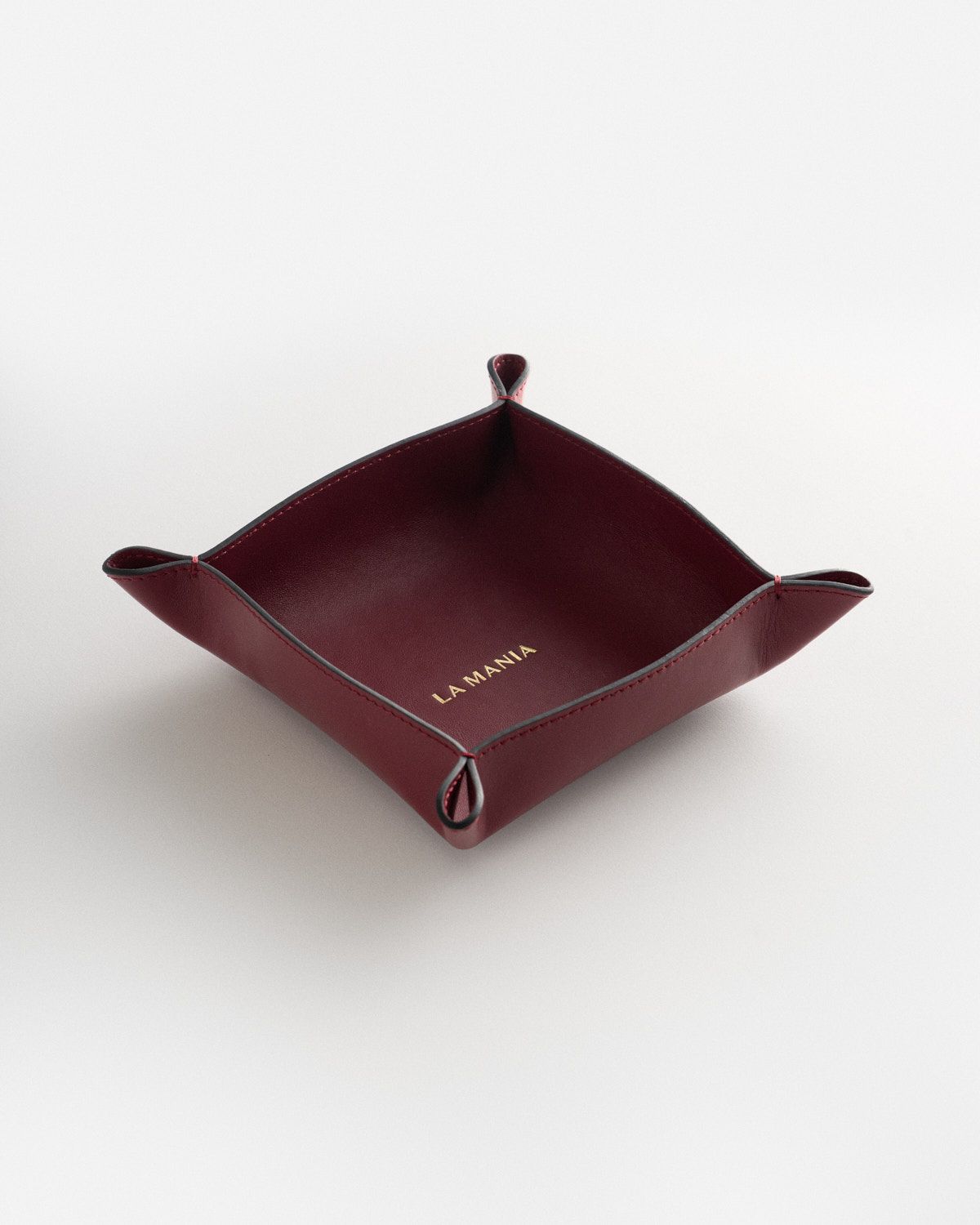 a red leather tray on a white surface