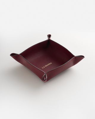 a red leather tray on a white surface