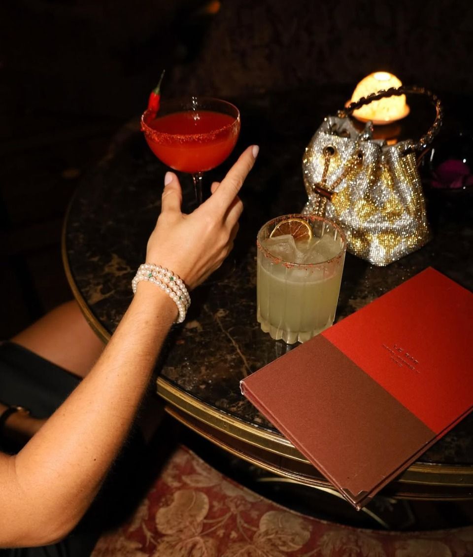 a person holding a drink on a table