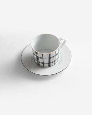 a black and white cup and saucer on a plate