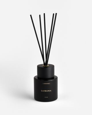 a black bottle with a black candle inside of it