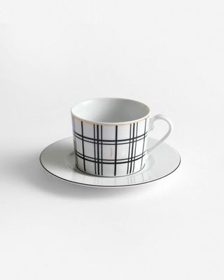 a black and white cup and saucer on a white background