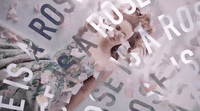 a woman standing in front of a wall covered in letters