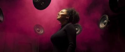 a woman standing in front of speakers in a room