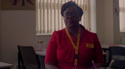 a woman in a red shirt is sitting at a table