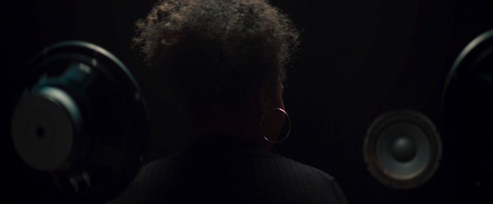 a woman standing in front of some speakers