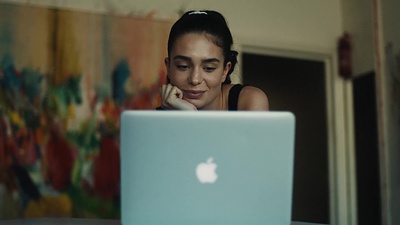 a woman sitting in front of a laptop computer