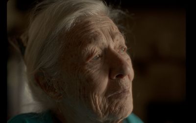 an old woman with white hair and a blue shirt