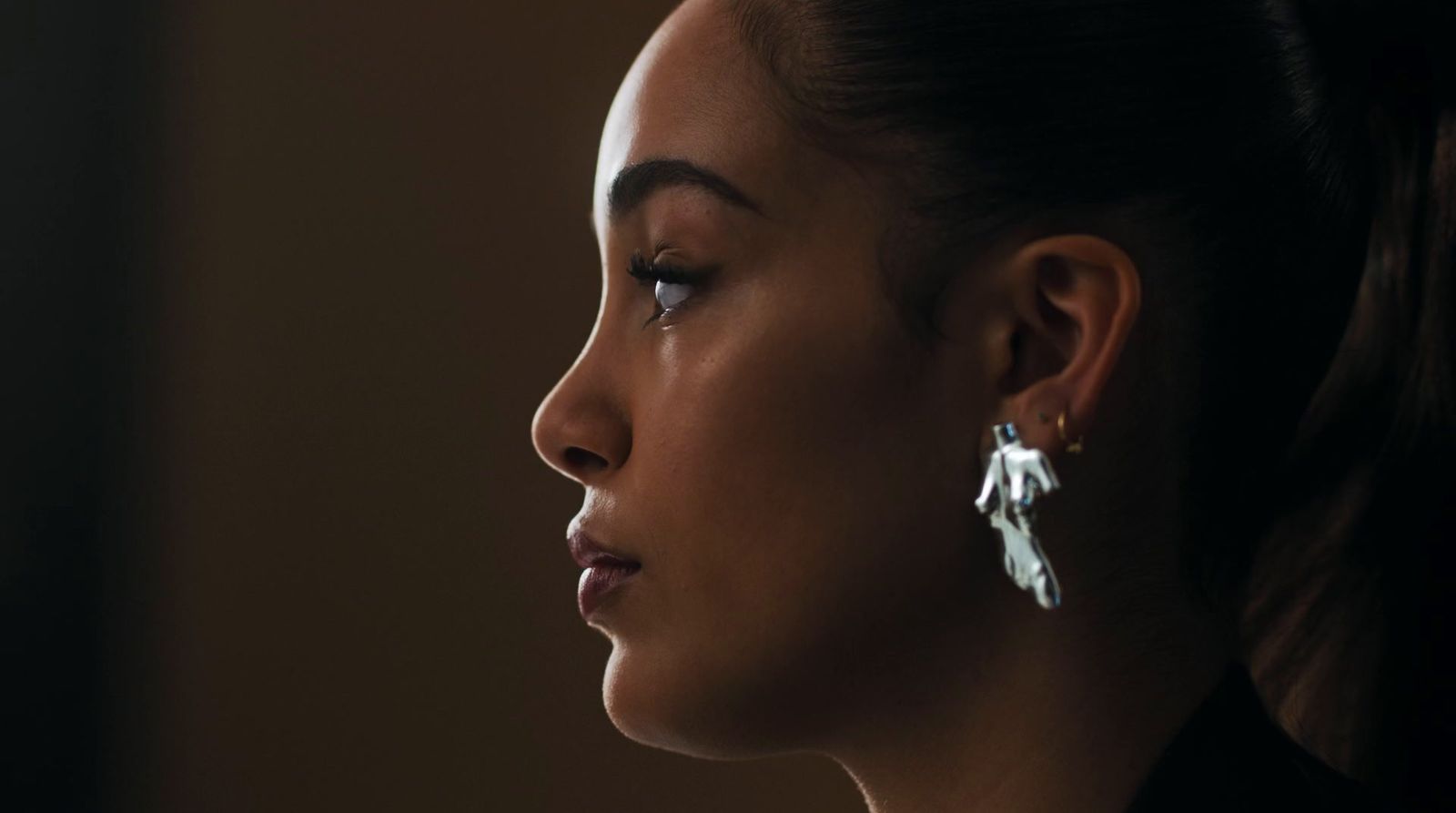 a close up of a person wearing a pair of earrings