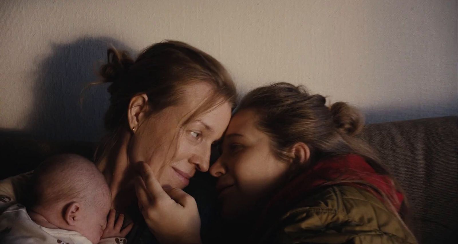 a woman holding a baby next to a woman holding a baby