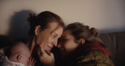 a woman holding a baby next to a woman holding a baby