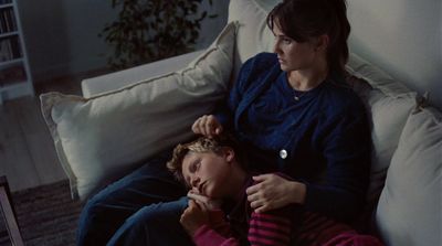 a woman sitting next to a woman on a couch
