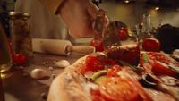 a person cutting a pizza on top of a table