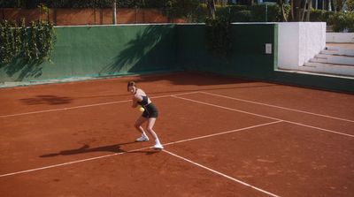 a woman standing on a tennis court holding a racquet