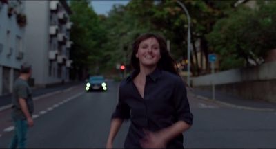 a woman walking down a street next to a man