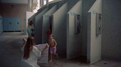 a group of people standing around a bathroom stall