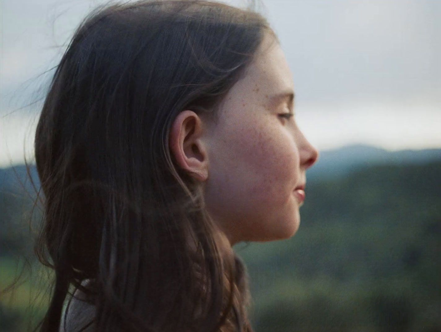 a woman with long hair looking off into the distance