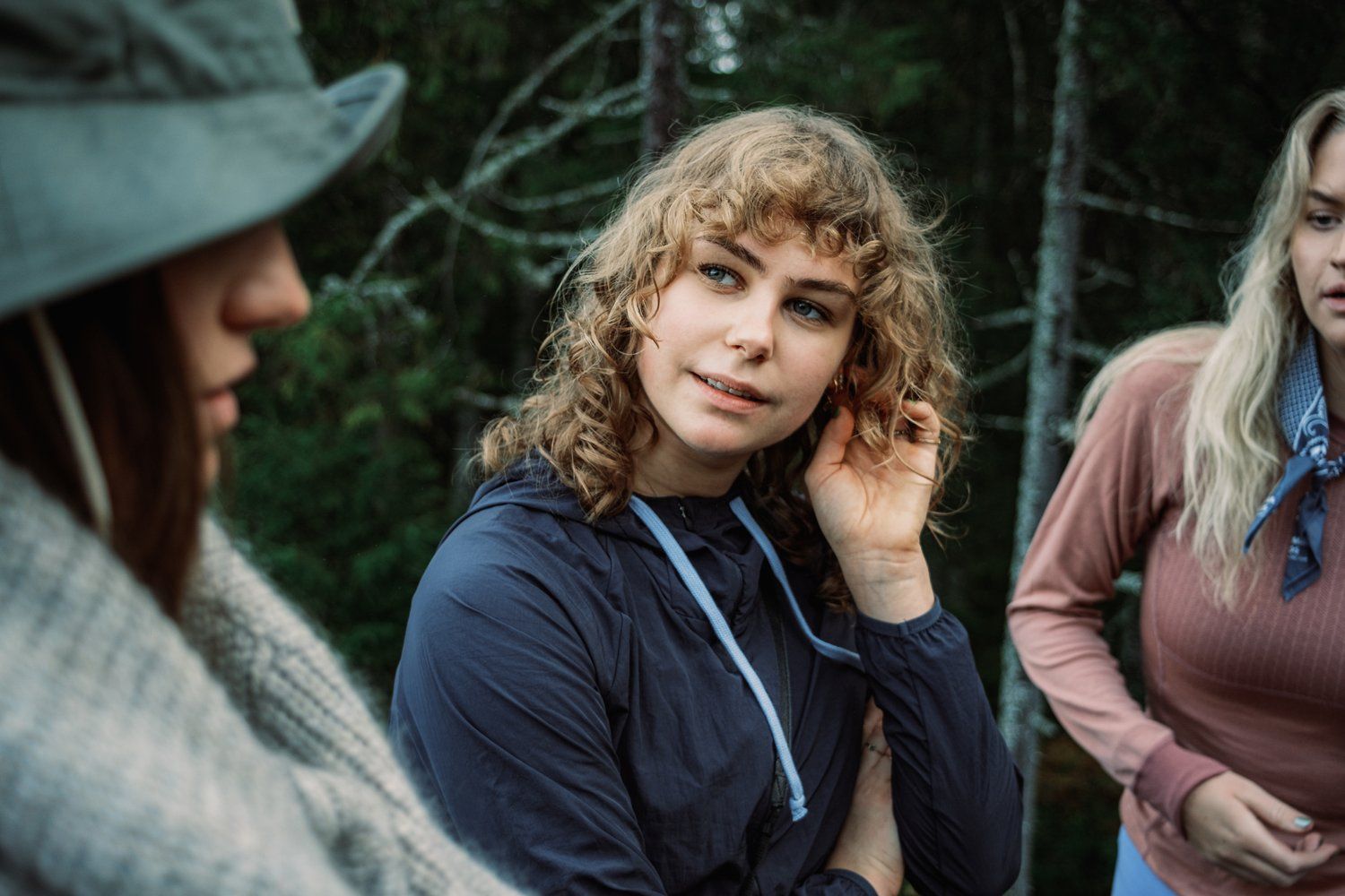 a woman with curly hair standing next to another woman