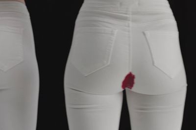 a pair of white jeans with a red patch on the side