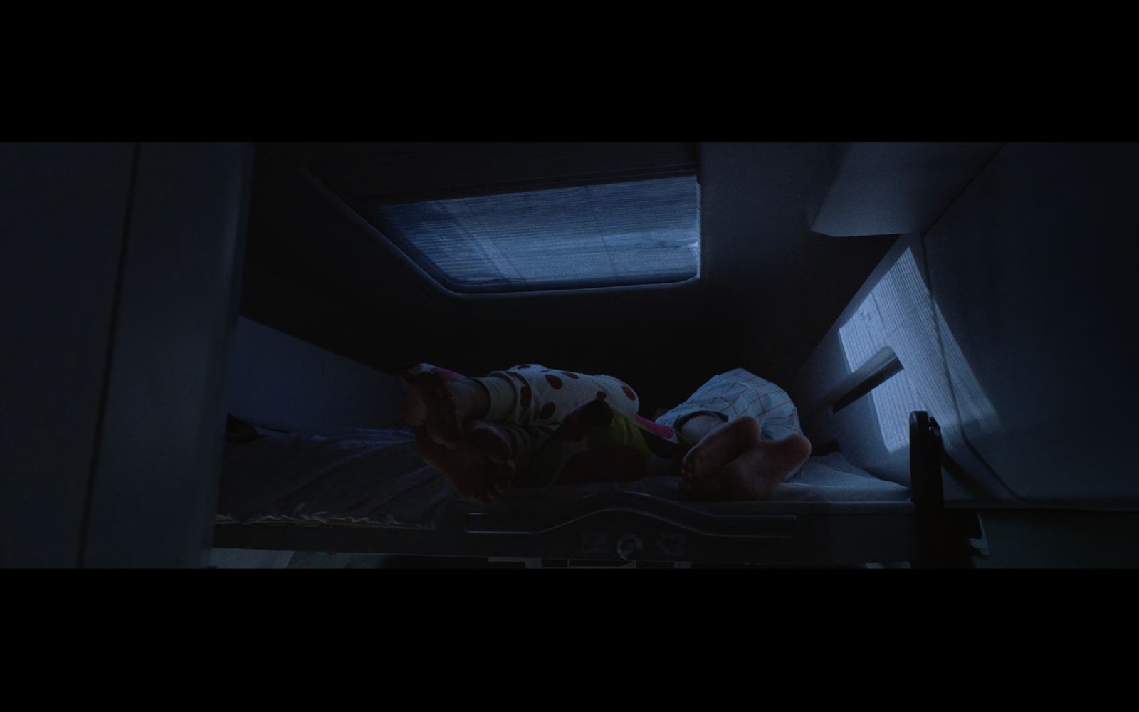 a person laying on a bed in a dark room