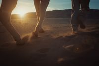 a couple of people that are walking in the sand