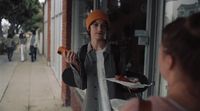 a woman holding a plate of food in front of a store