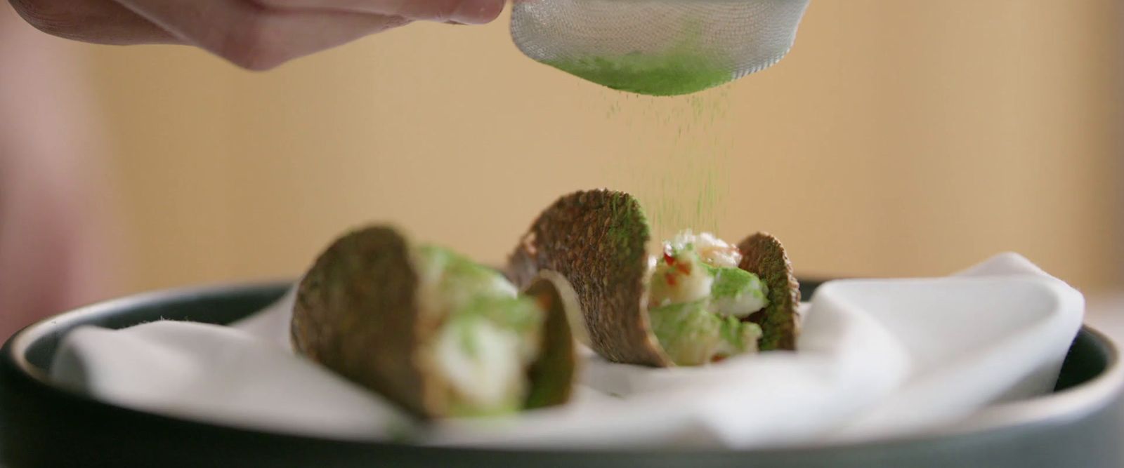 a person is sprinkling something on a dessert