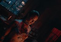 a woman with tattoos standing in a dark room