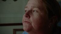 a woman with blue eyes looking off into the distance