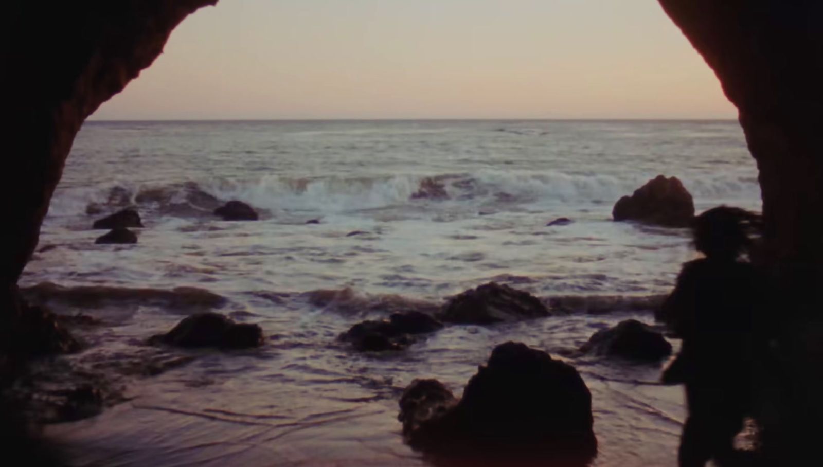 a view of a body of water from inside a cave