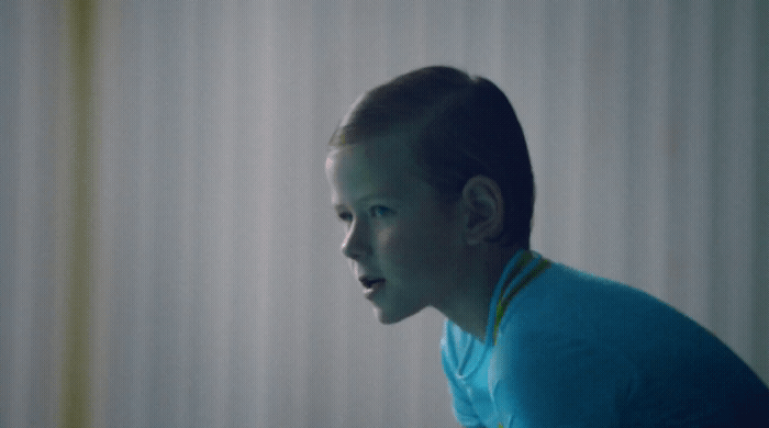 a boy in a blue shirt is staring at something