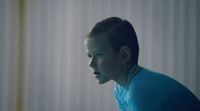 a boy in a blue shirt is staring at something