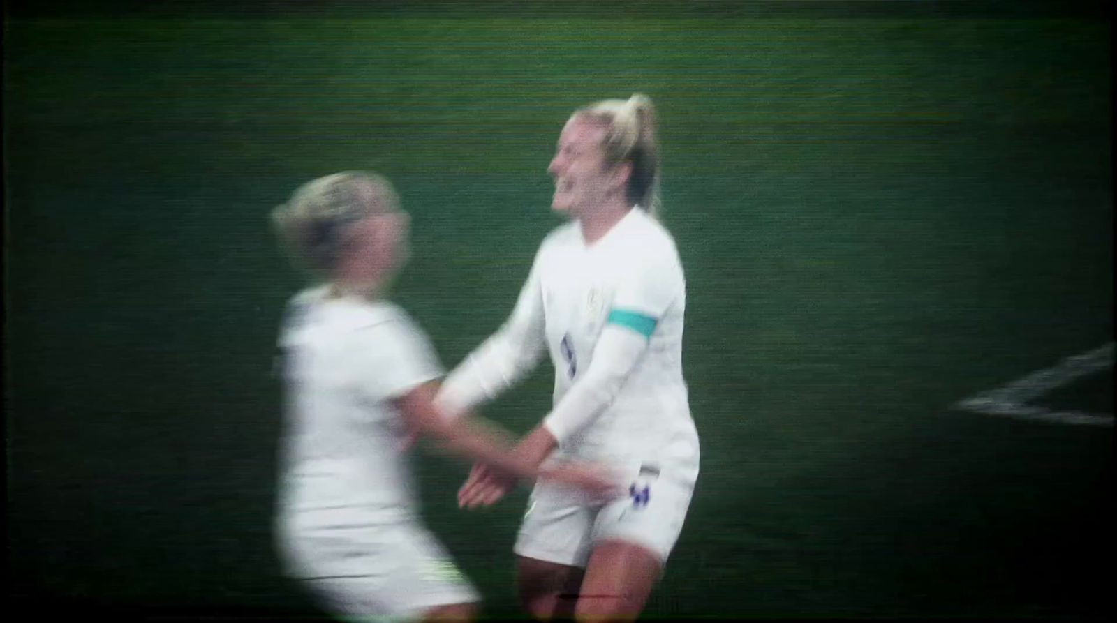 a couple of women standing next to each other on a field