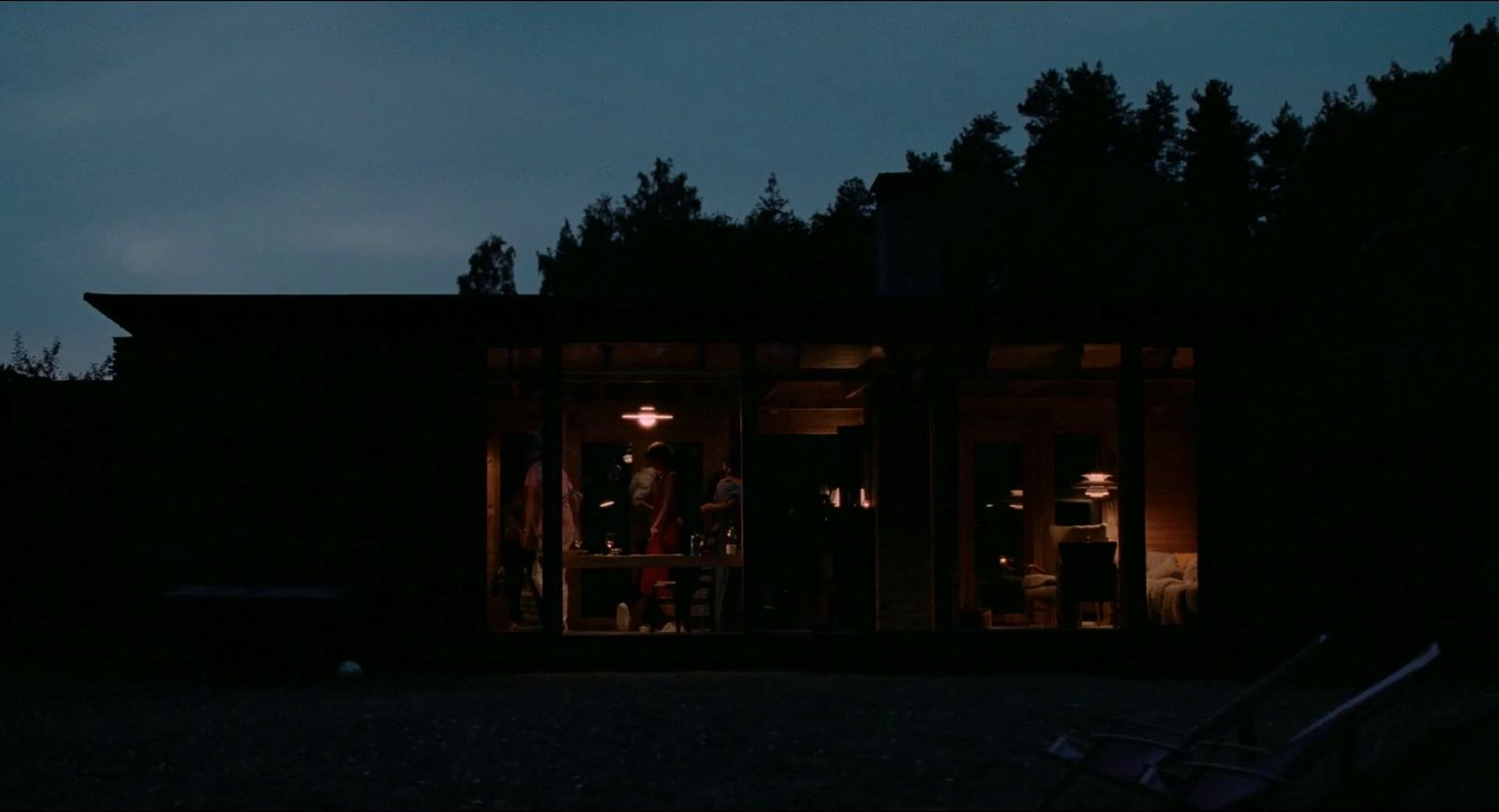 a group of people standing outside of a building at night