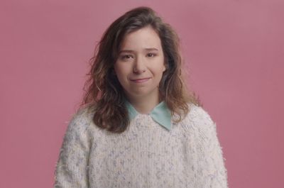 a woman in a white sweater posing for a picture