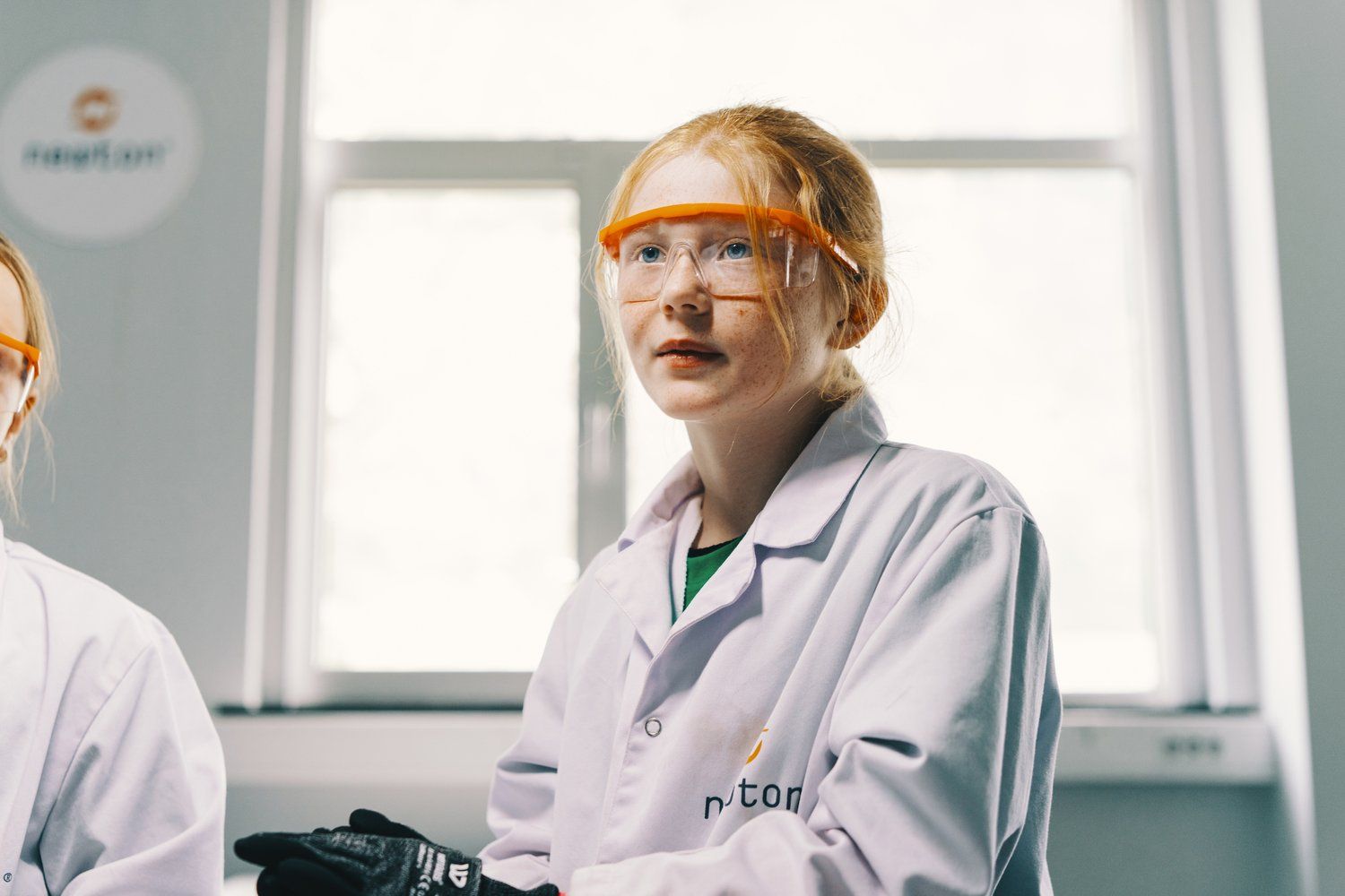 a couple of women in lab coats standing next to each other