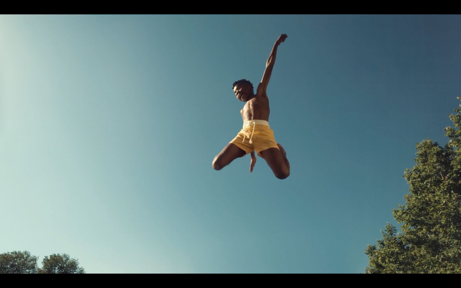 a man in yellow shorts jumping in the air