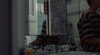 a young boy standing in front of a bathroom mirror
