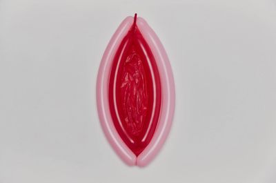 a red object is hanging on a white wall