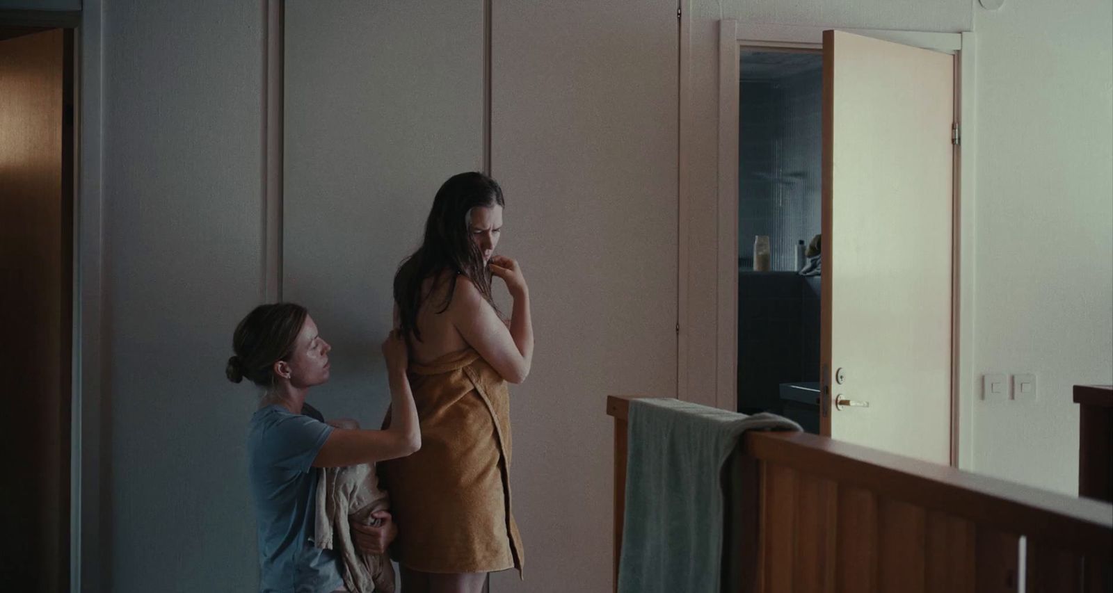 a woman standing next to a woman brushing her teeth