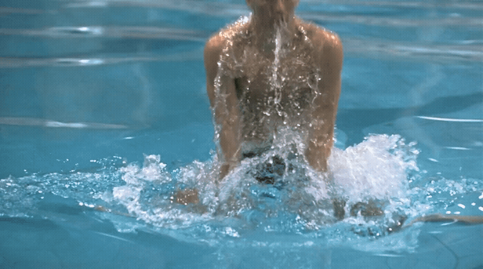 a person in a swimming pool with a frisbee