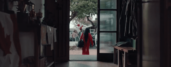 a woman in a red dress walking into a hallway